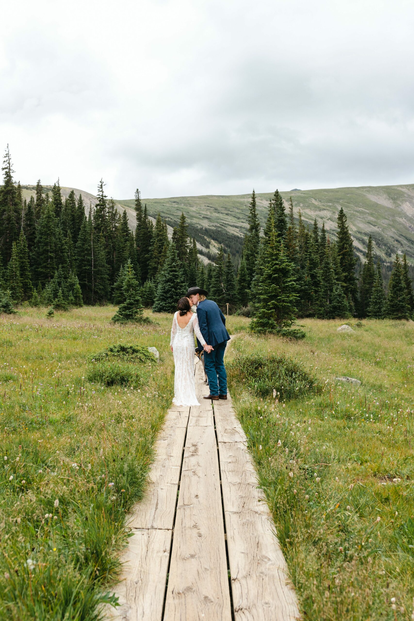 bride and groom kissing on trail