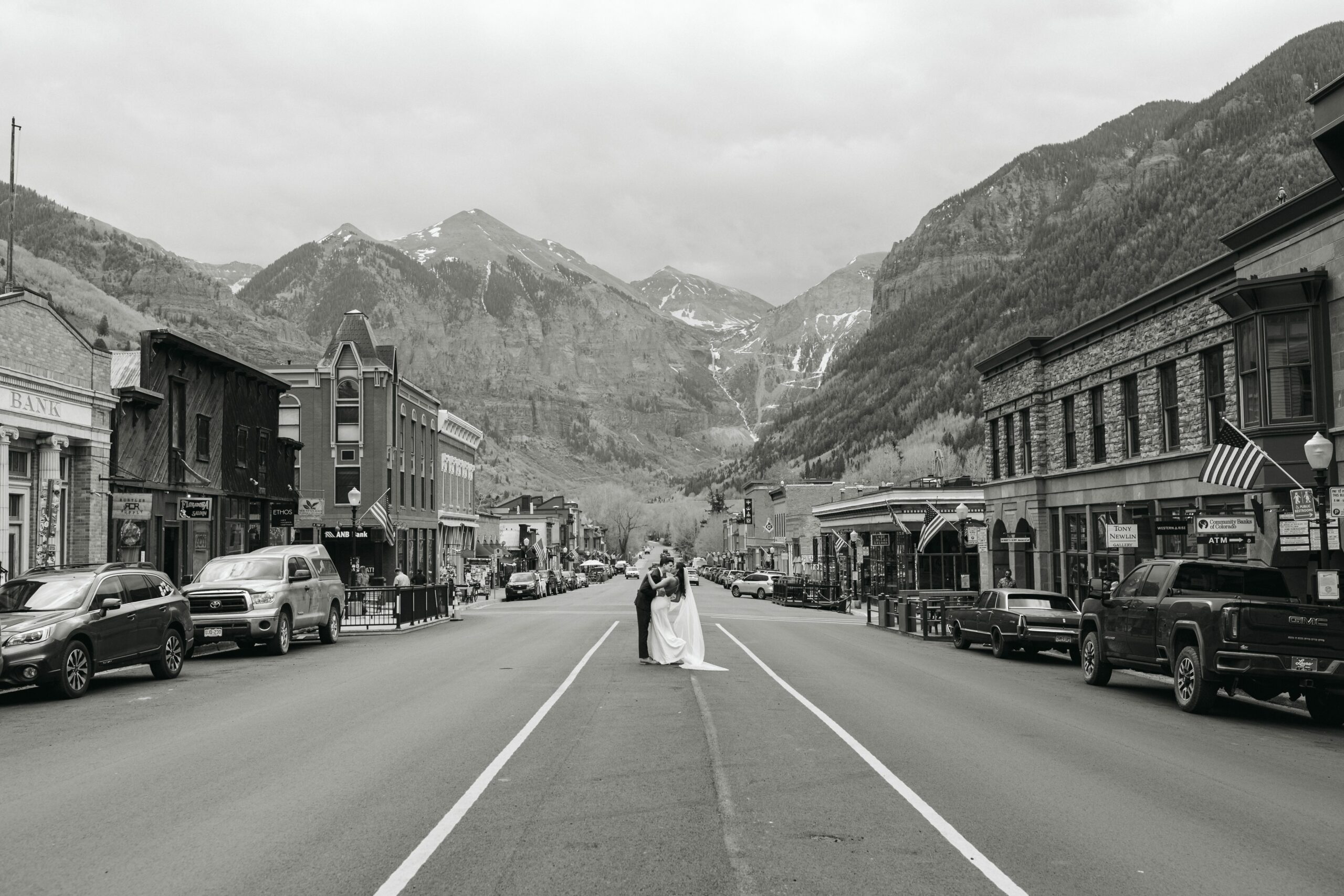 black and white photo of couple kissing on a road