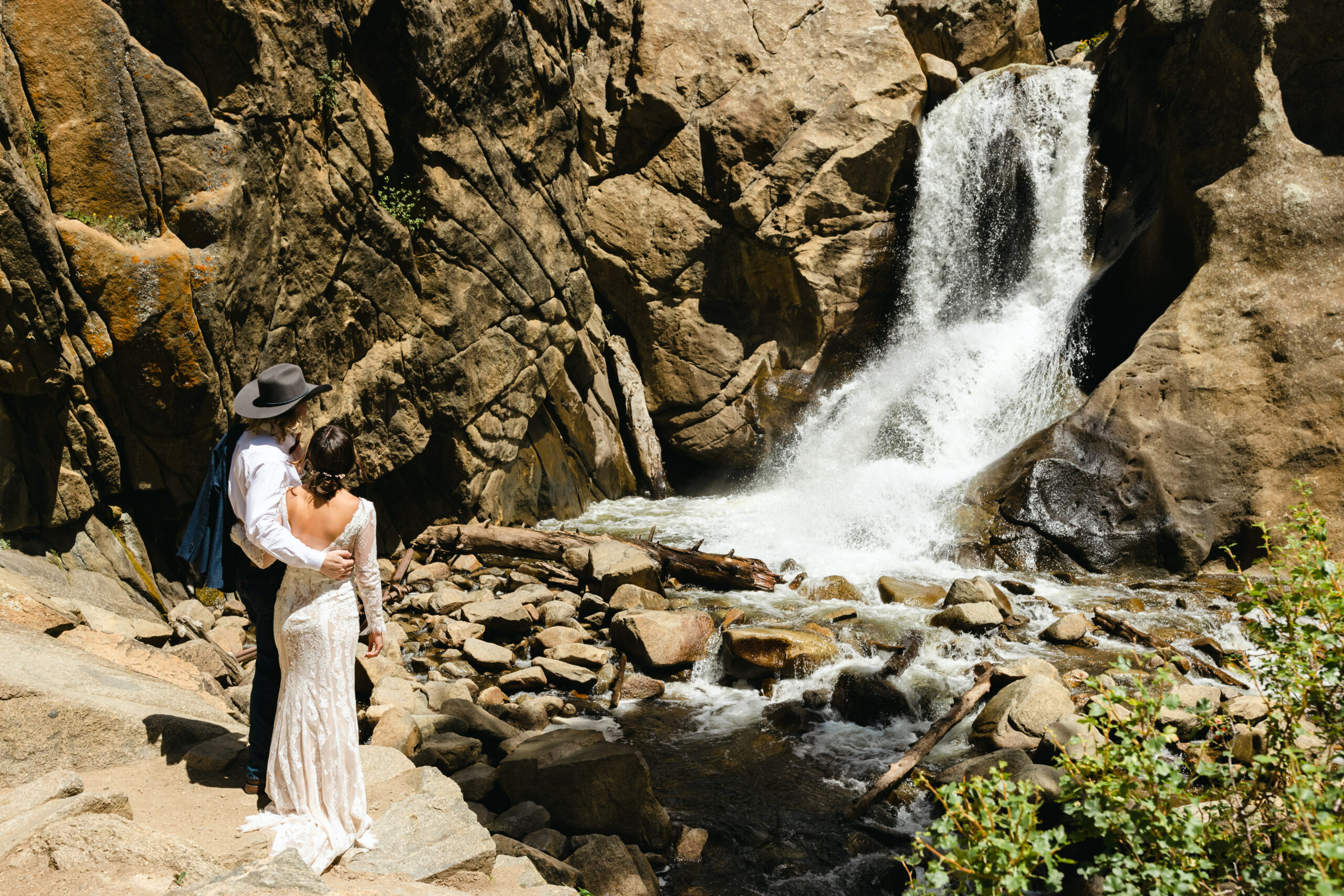 bride and groom looking at waterfalls