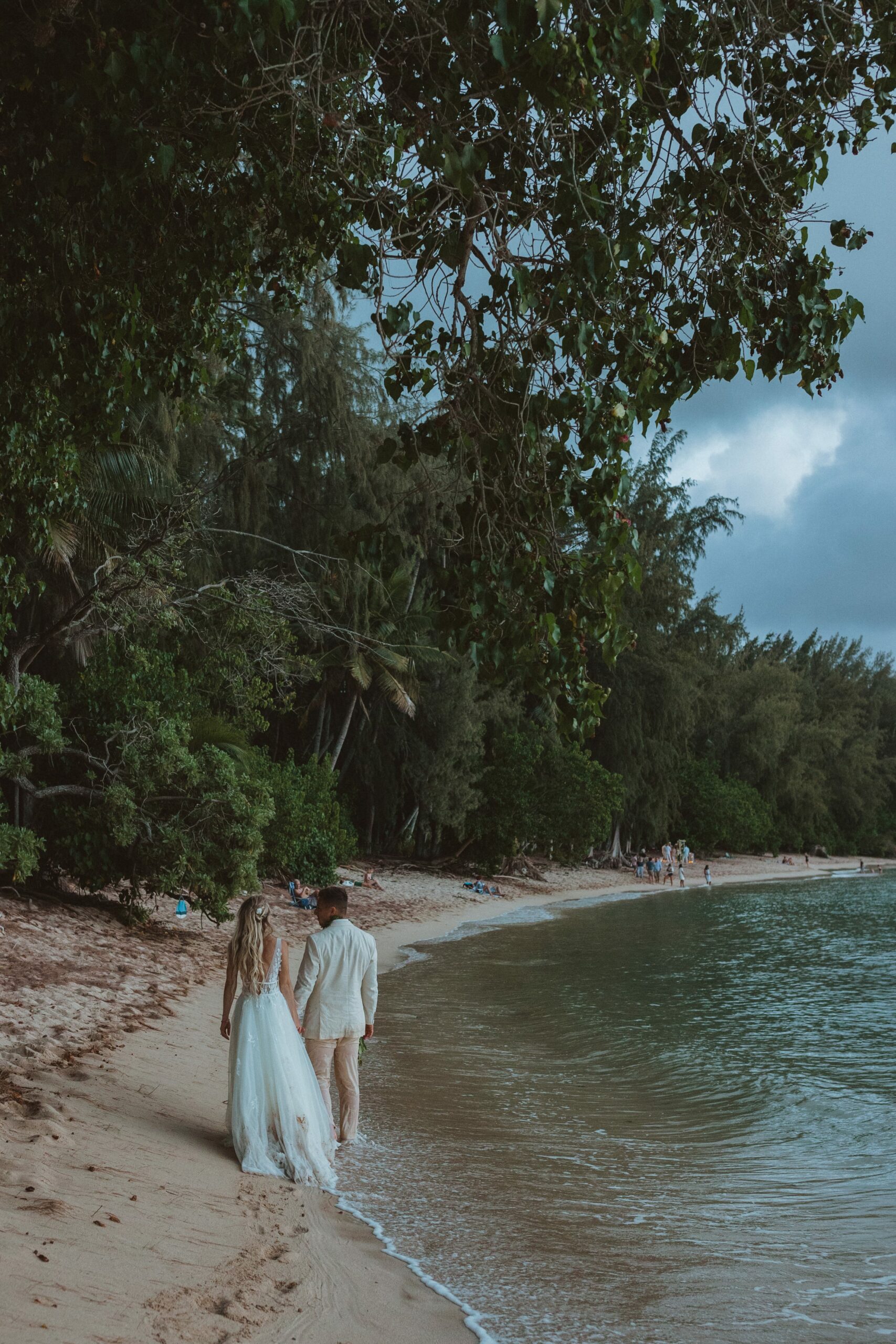 bride and groom walking along beach