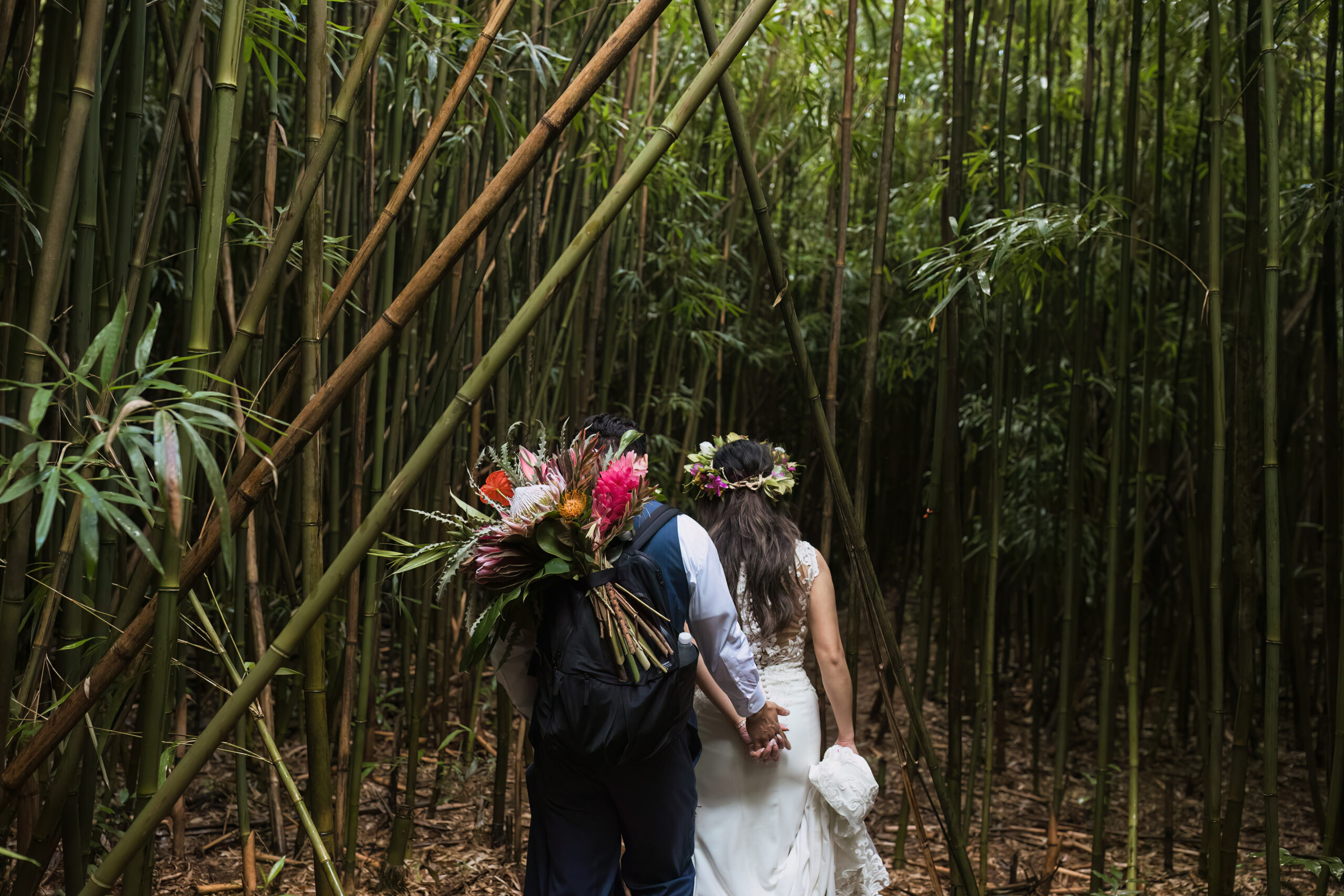 bride and groom walking through trees